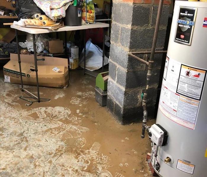 A photo of a basement floor covered in mud from a rain storm